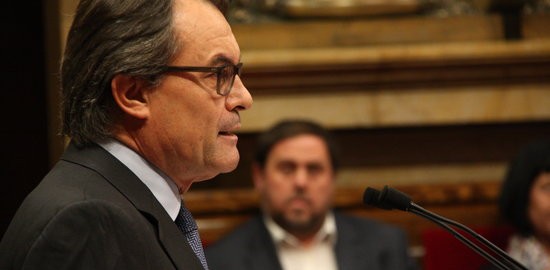 El president de la Generalitat en funcions, Artur Mas, al faristol del parlament, de perfil, amb el líder d'ERC, Oriol Junqueras, de fons.