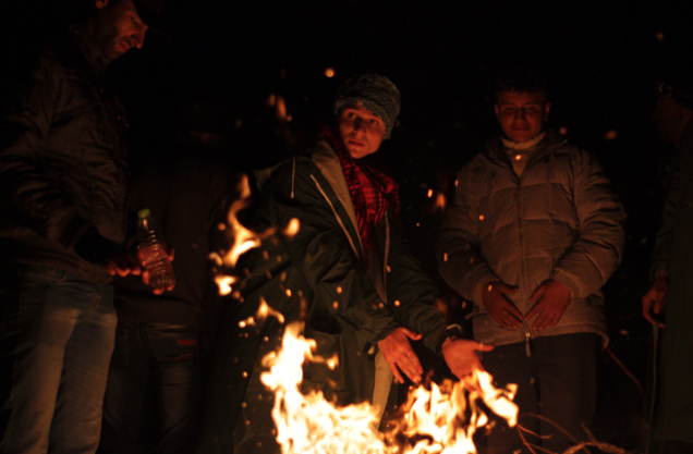 Refugiats escalfant-se al voltant d’una foguera (fotografia: Oriol Bäbler).