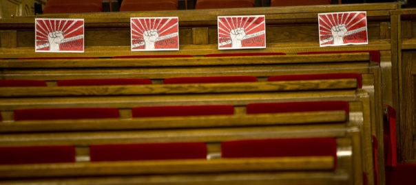 Els cartells de la CUP a favor del 'poder del poble', als seus escons del parlament, a l'hora que havia de començar el ple d'investidura.