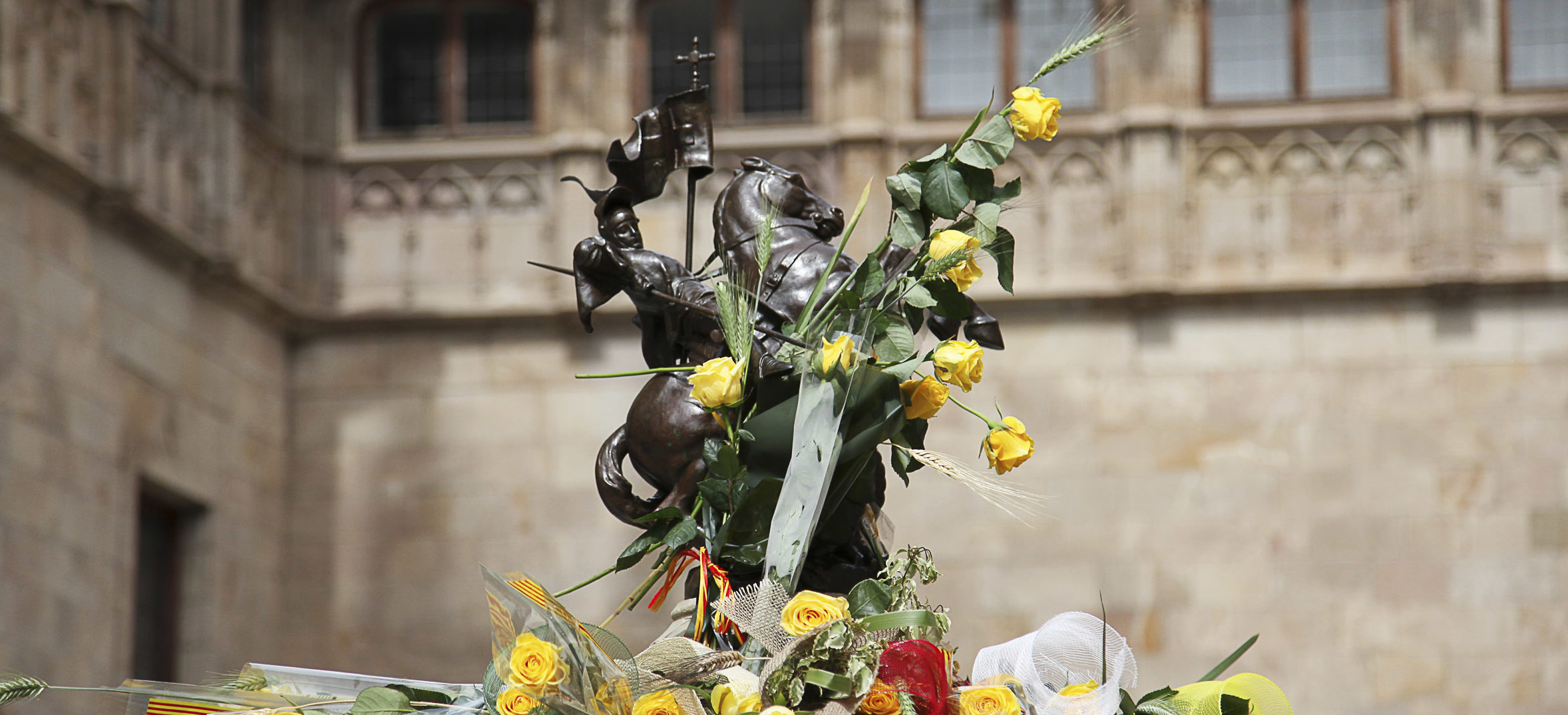 Els visitants del Palau deixen roses grogues a la figura de sant Jordi que corona la font del Pati dels Tarongers (fotografia: Elisabeth Magre)