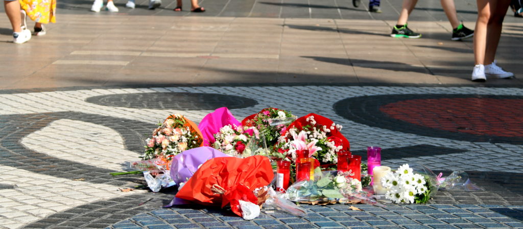 Flors i espelmes que guarneixen la Rambla a l'alçada del pla de l'Os el dia abans de l'aniversari dels atemptats