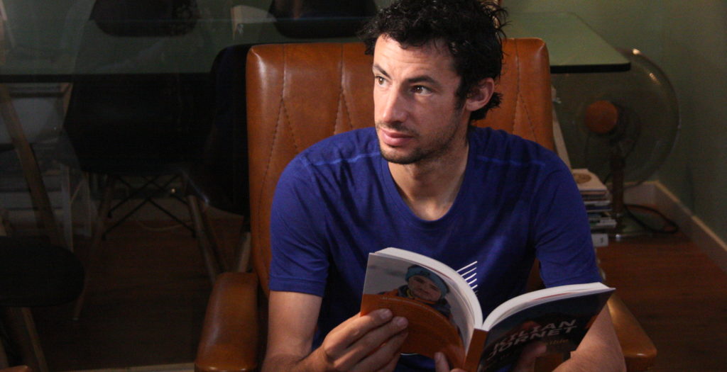 Kilian Jornet, assegut a una butaca i fullejant el nou llibre que acaba de publicar, 'Res és impossible'