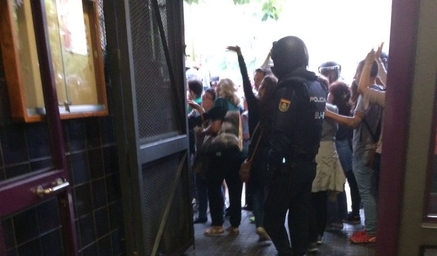 Un agent de la policia espanyola després d'esbotzar la porta d'entrada a l'escola Estel. Fotografia: Catmemòria