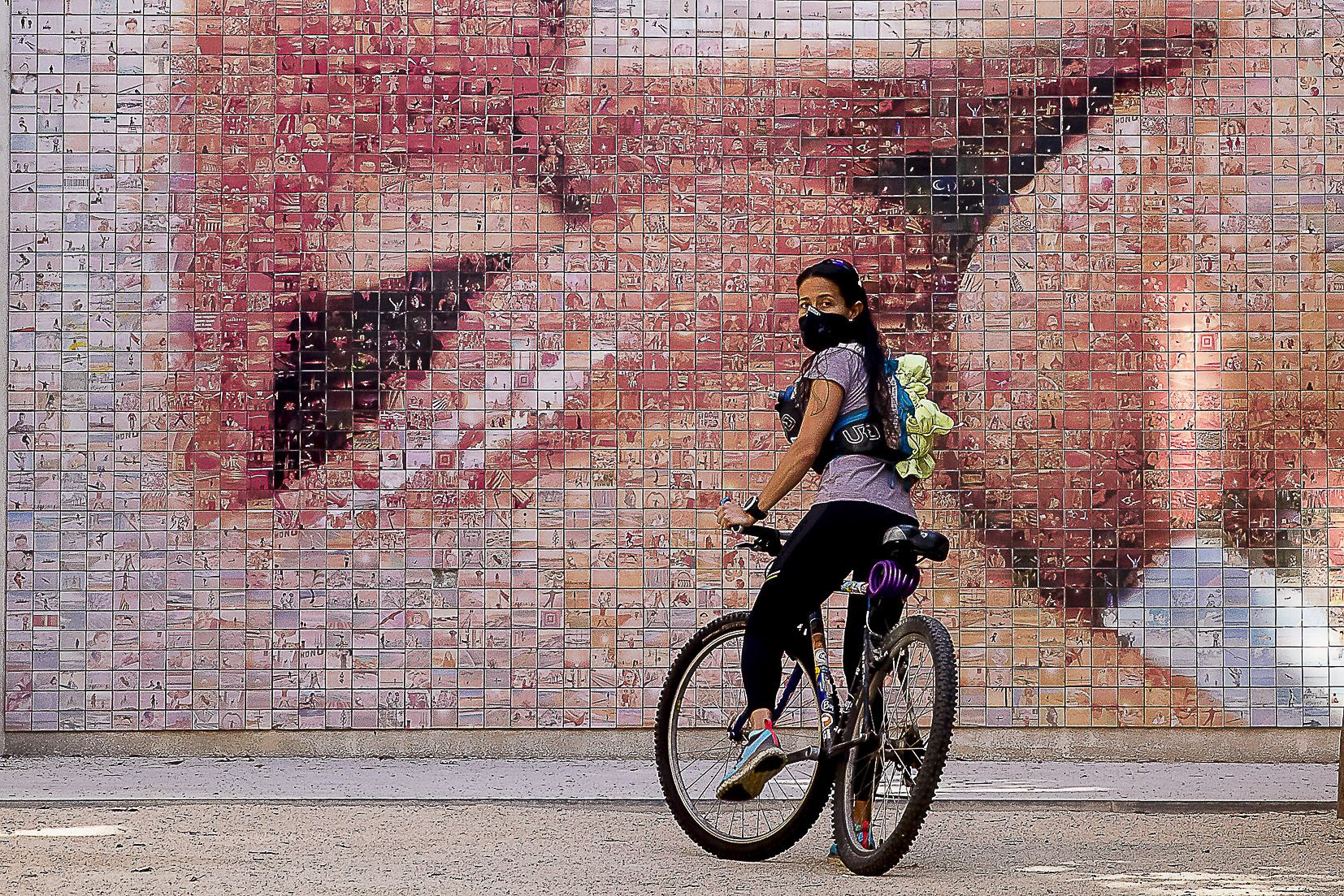 Una jove amb mascareta davant el Petó, fotomosaic de Joan Fontcuberta, a Barcelona (Foto: Albert Salamé)
