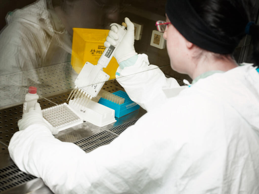 Imatge d'una investigadora treballant al laboratori del CReSA.