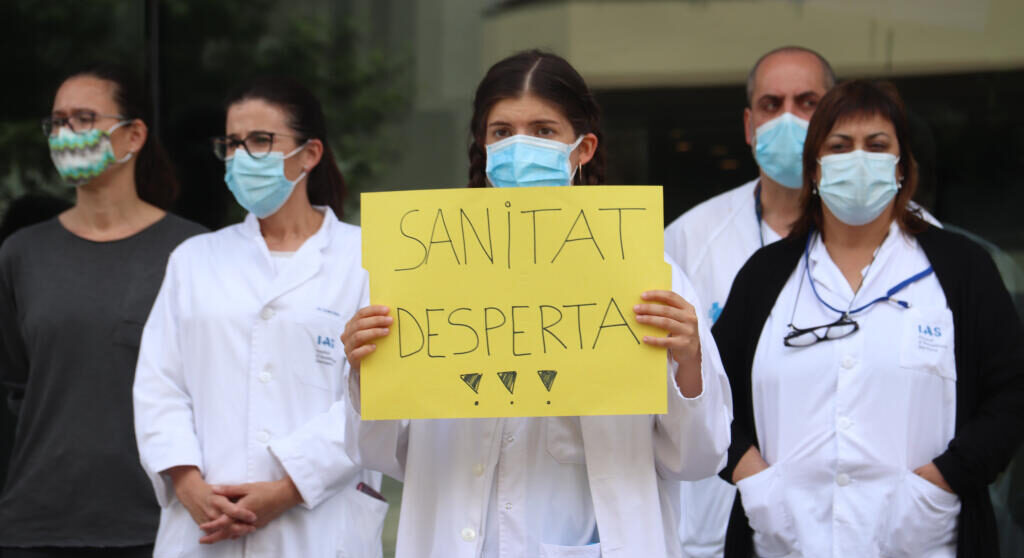 Una infermera amb una pancarta defensant la salut pública durant una mobilització davant de la Delegació de la Generalitat a Girona. Fotografia: ACN