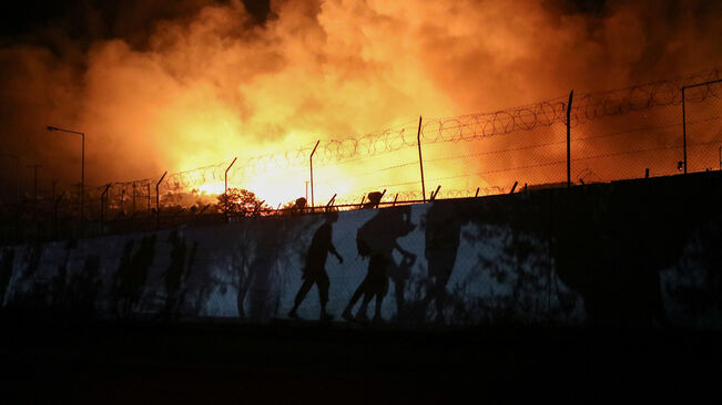 Refugiats fugint del camp de Mòria en flames. Fotografia: Elias Marcou (Reuters)