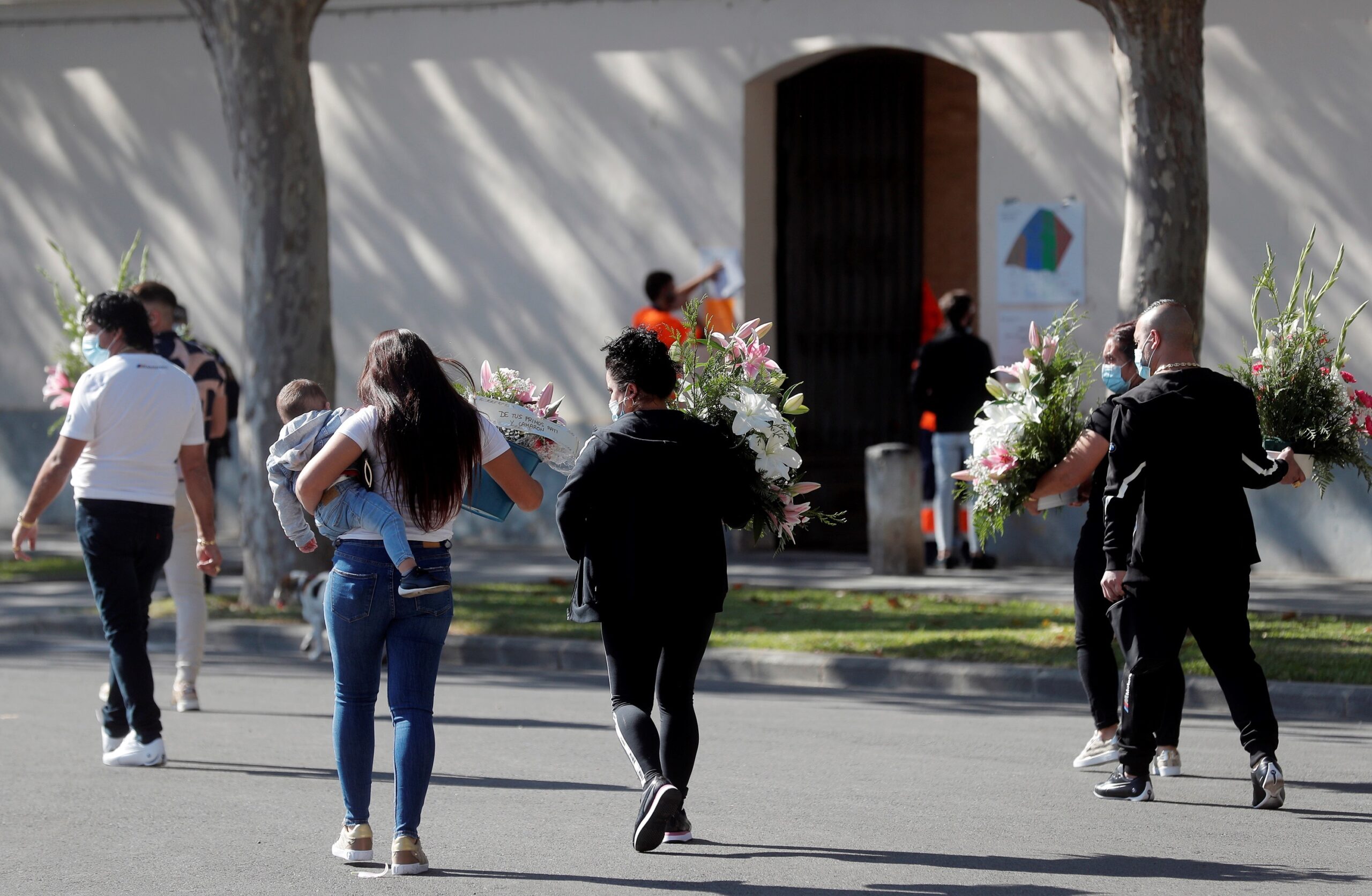 Diverses persones porten flors al cementiri general de València. Fotografia: EFE/Kai Försterling