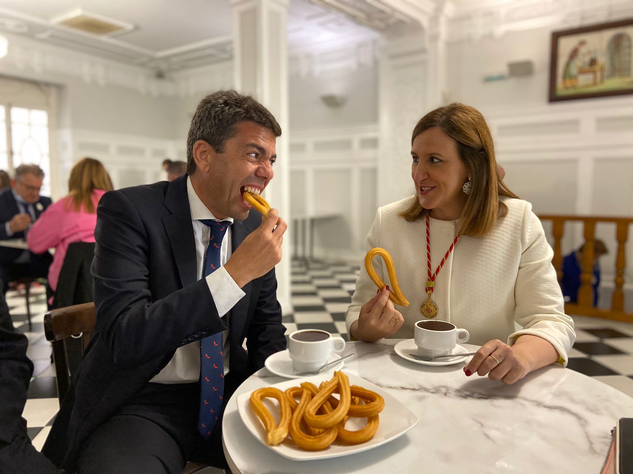 Carlos Mazón es menja un xurro amb Maria José Català el dia de la Mare de Déu dels Desemparats