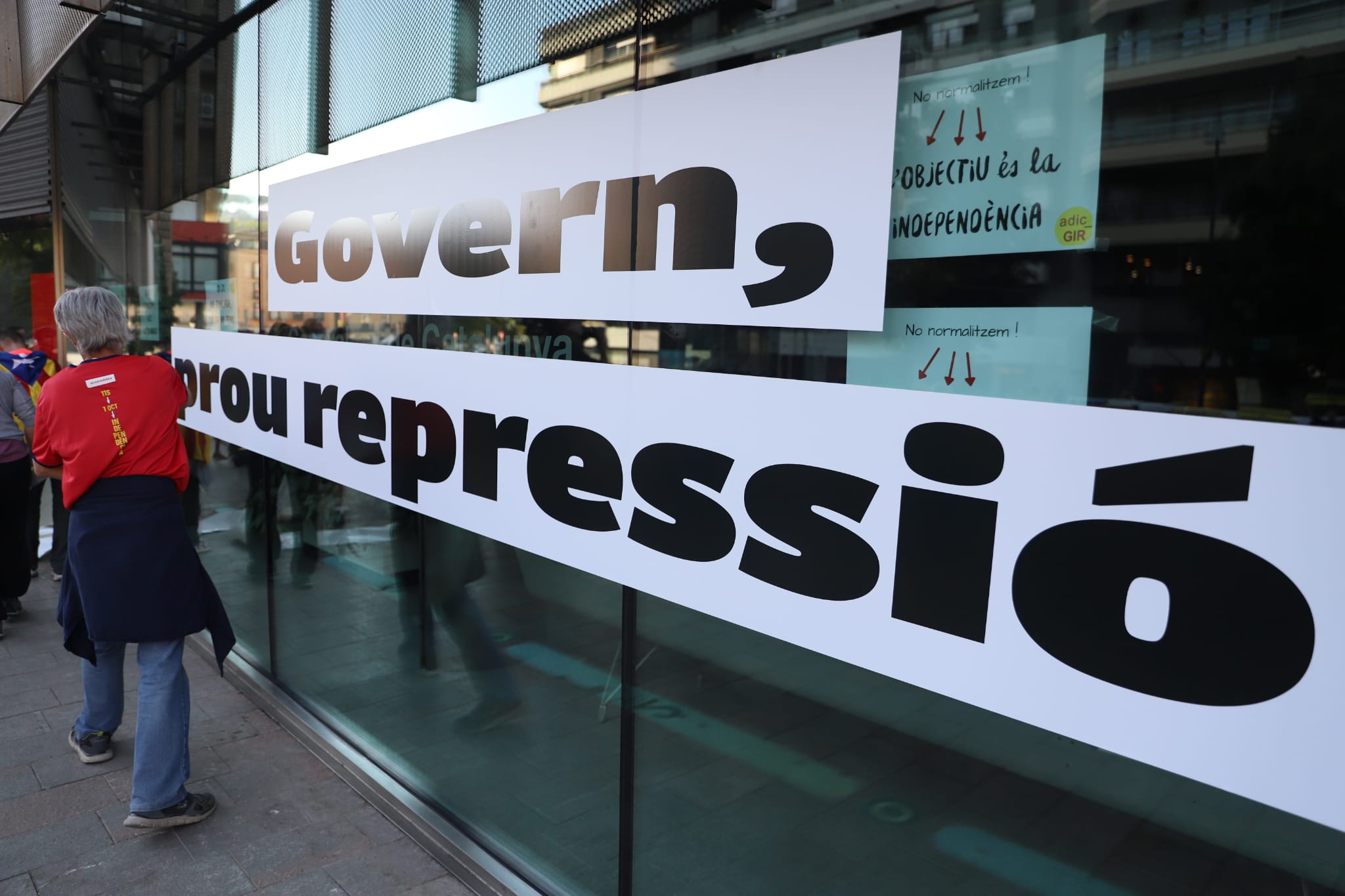 Pancarta enganxada a la porta de la seu de la Generalitat a Girona, durant el pas de la marxa de dissabte.