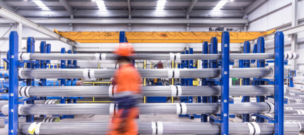 Un operari passa per davant de barres calibrades a una planta de Celsa.