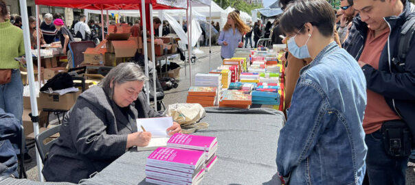 Carme Junyent signa 'Som dones, som lingüistes, som moltes i diem prou' a la parada de la llibreria Documenta (fotografia: Eumo Editorial).