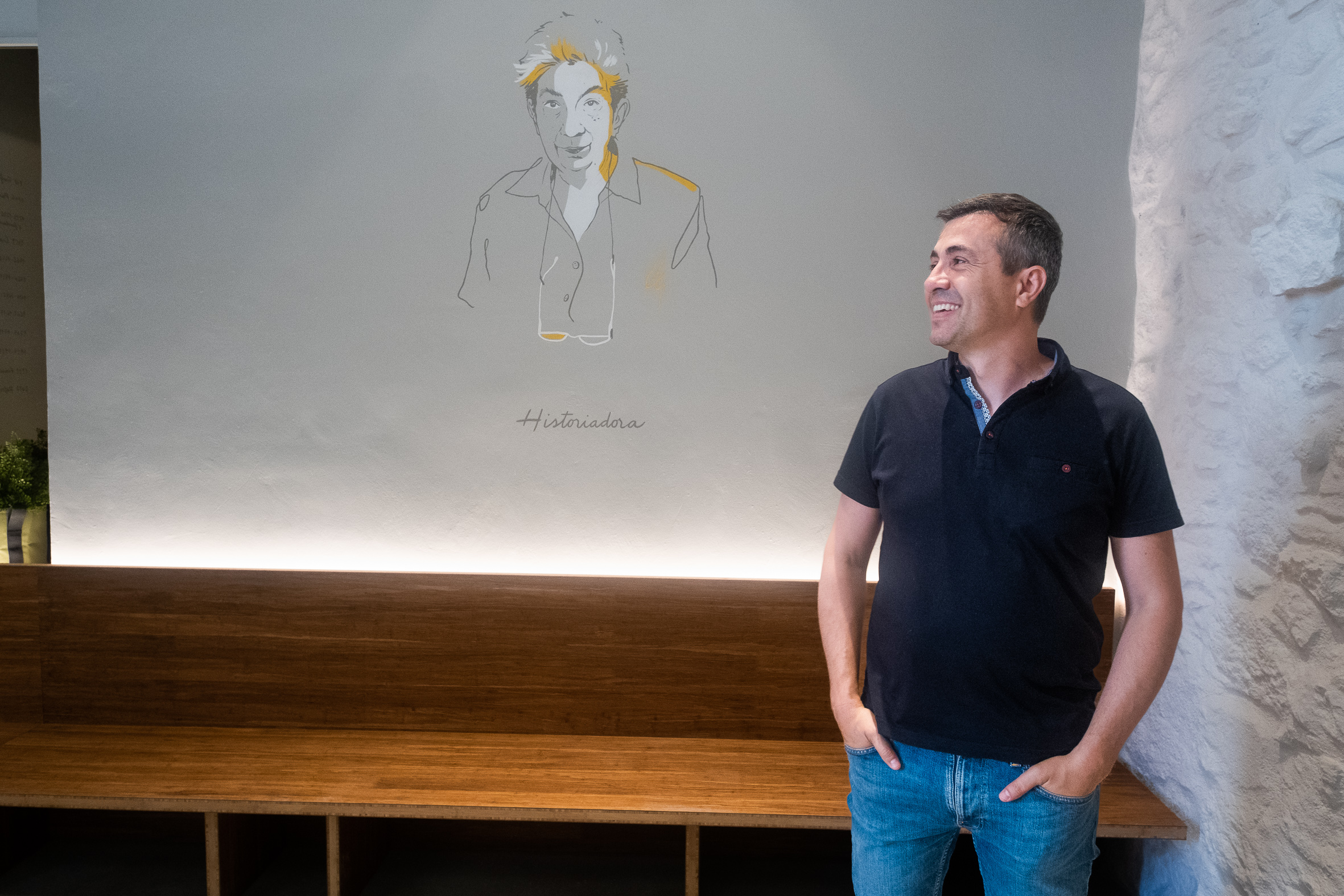 Candi Granés, de 45 anys, dins un dels quatre locals que té al barri vell de Girona. A la paret, il·lustració d'Eva Serra, historiadora (Foto: Adiva Koenigsberg)