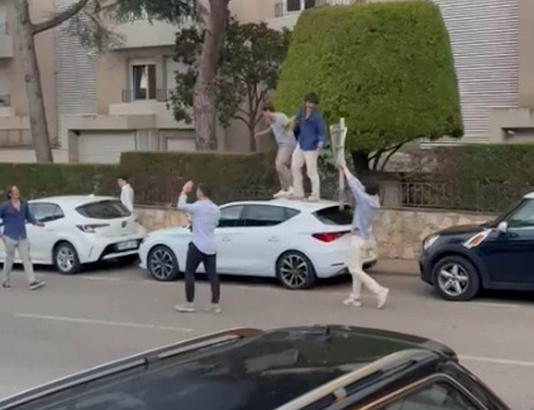 Captura del vídeo publicat a les xarxes socials on un grup de joves salta sobre el capó d'un cotxe