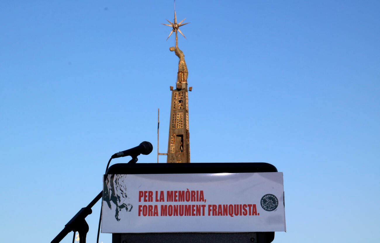 El monument franquista de Tortosa rere una pancarta pel seu desmantellament.
