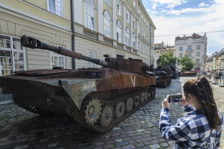 Una dona fotografia un tanc rus destruït, en una exposició que s'ha fet al carrer de Lviv el 10 d'agost de 2022 (fotografia: Mykola Tys/EPA/EFE).