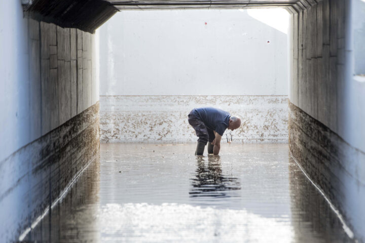 Un operari de l'ajuntament des Castell (Menorca) intenta desembussar la sortida dels pluvials d'un túnel subterrani després de la pluja intensa. Fotografia: EFE/David Arquimbau Sintes