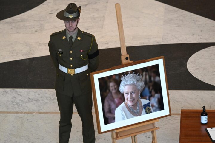 Un membre de les forces d'autodefensa d'Austràlia fa guàrdia al costat d'un retrat de la reina Elisabet II. (Fotografia de Mick Tsikas)