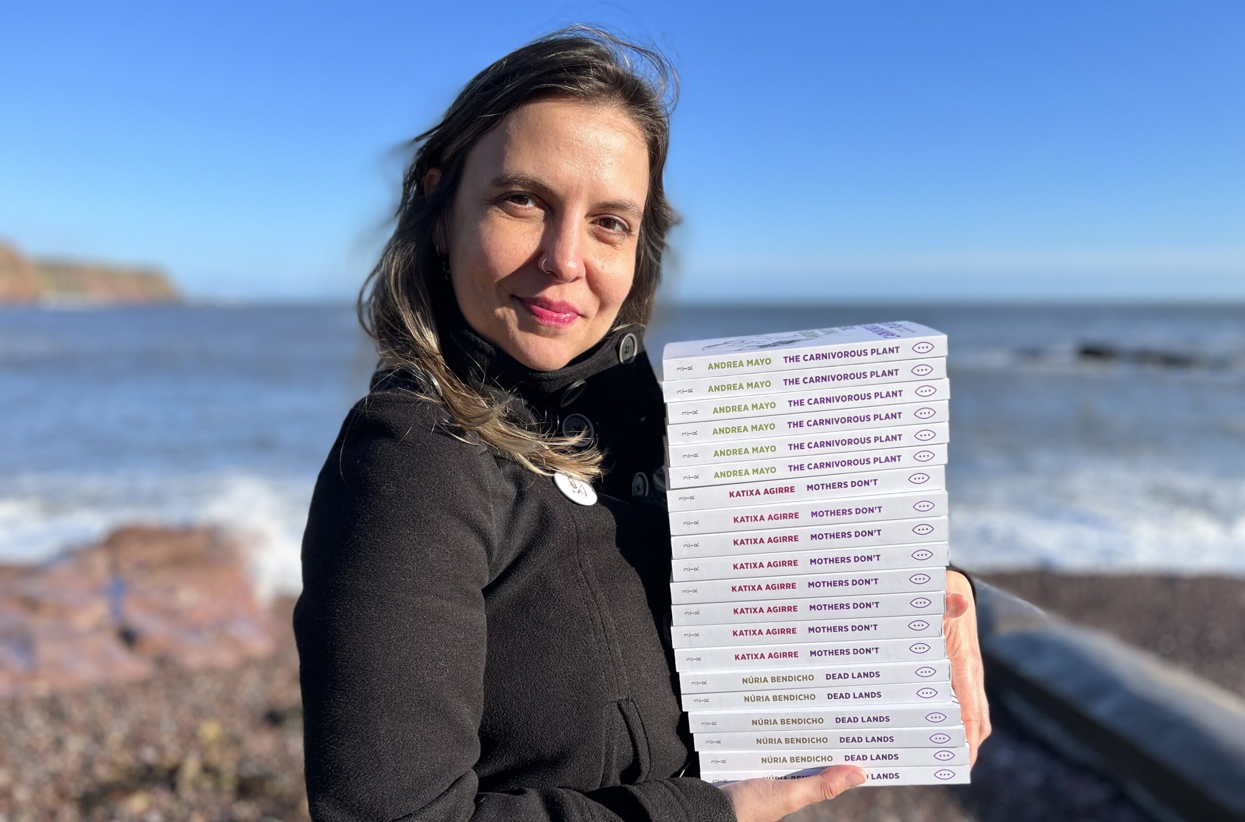 L'editora de 3TimesRebel, Bibiana Mas, sosté un piló de llibres. Fotografia: Pópulo Antolín