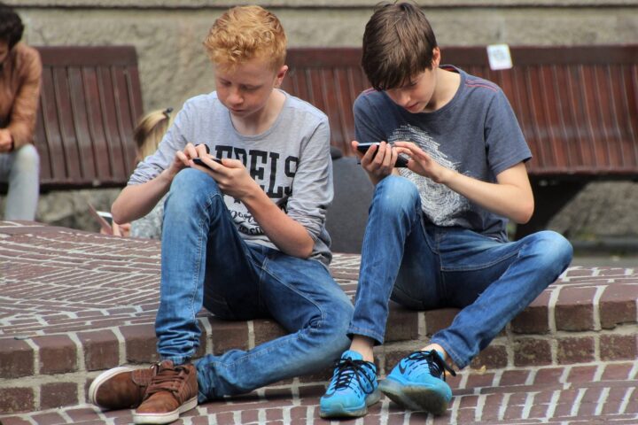 Imatge d'arxiu de dos joves mirant el telèfon mòbil.