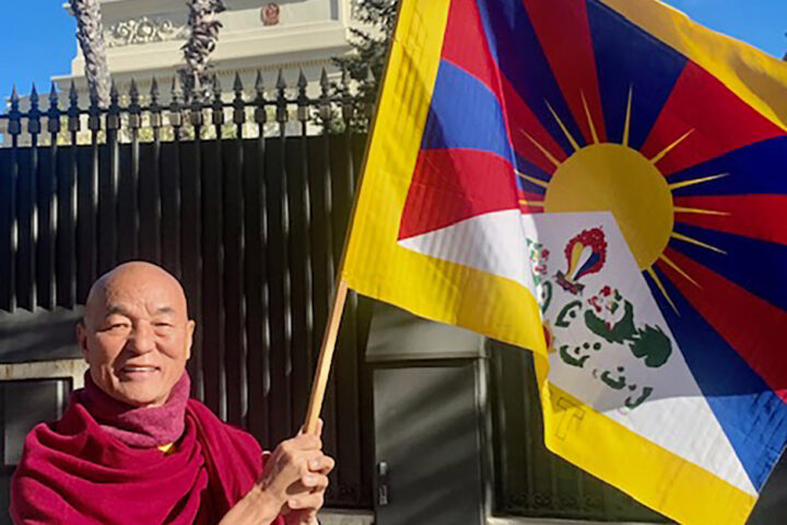 Thubten Wangchen fa onejar la bandera tibetana davant el consolat de la Xina (fotografia: Casa del Tibet).