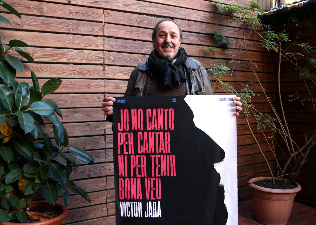 El director del festival Barnasants, Pere Camps, amb el cartell de l'edició del 2023 (fotografia: ACN/Pau Cortina).