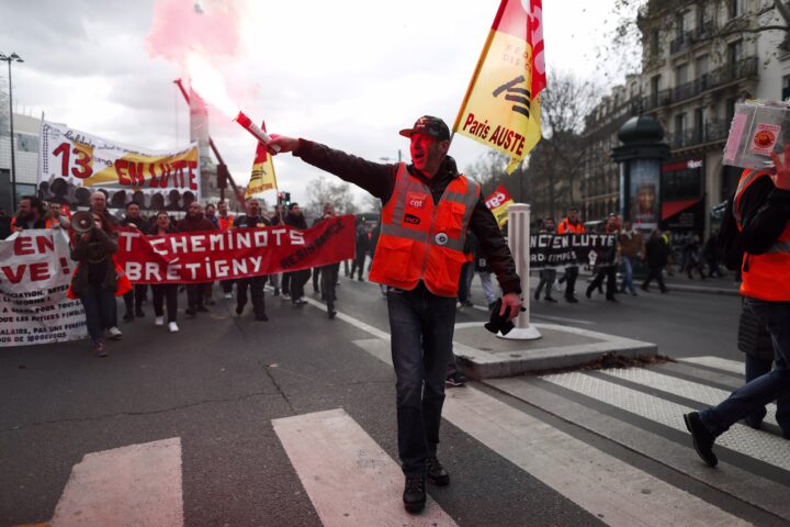 Un membre del sindicat CGT encén una bengala de fum mentre participa en la vaga general contra la reforma de les pensions a París. (Fotografia: Ian Langsdon. Desembre, 2019)