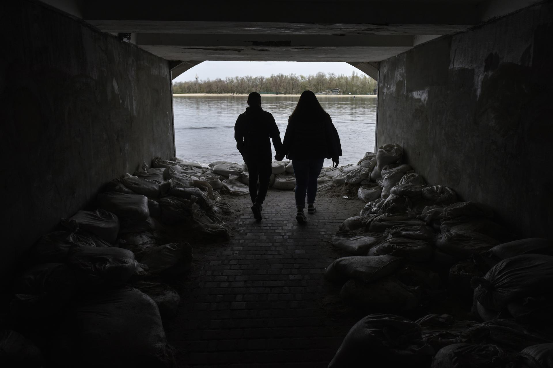 Dues persones s'acosten a la riba del Dniprò. (Fotografia d'Oleg Petrasyuk)