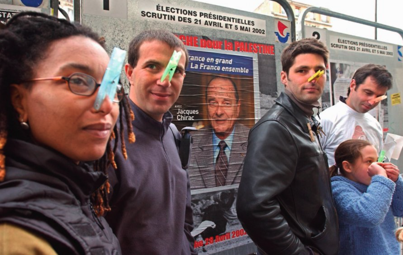 Un grup d'electors votant Chirac amb una agulla d'estendre al nas, l'any 2002.