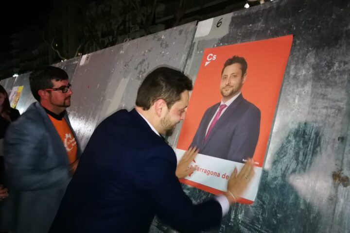 Rubén Viñuales enganxant un cartell electoral de Ciutadans amb la seva imatge en la campanya de 2019