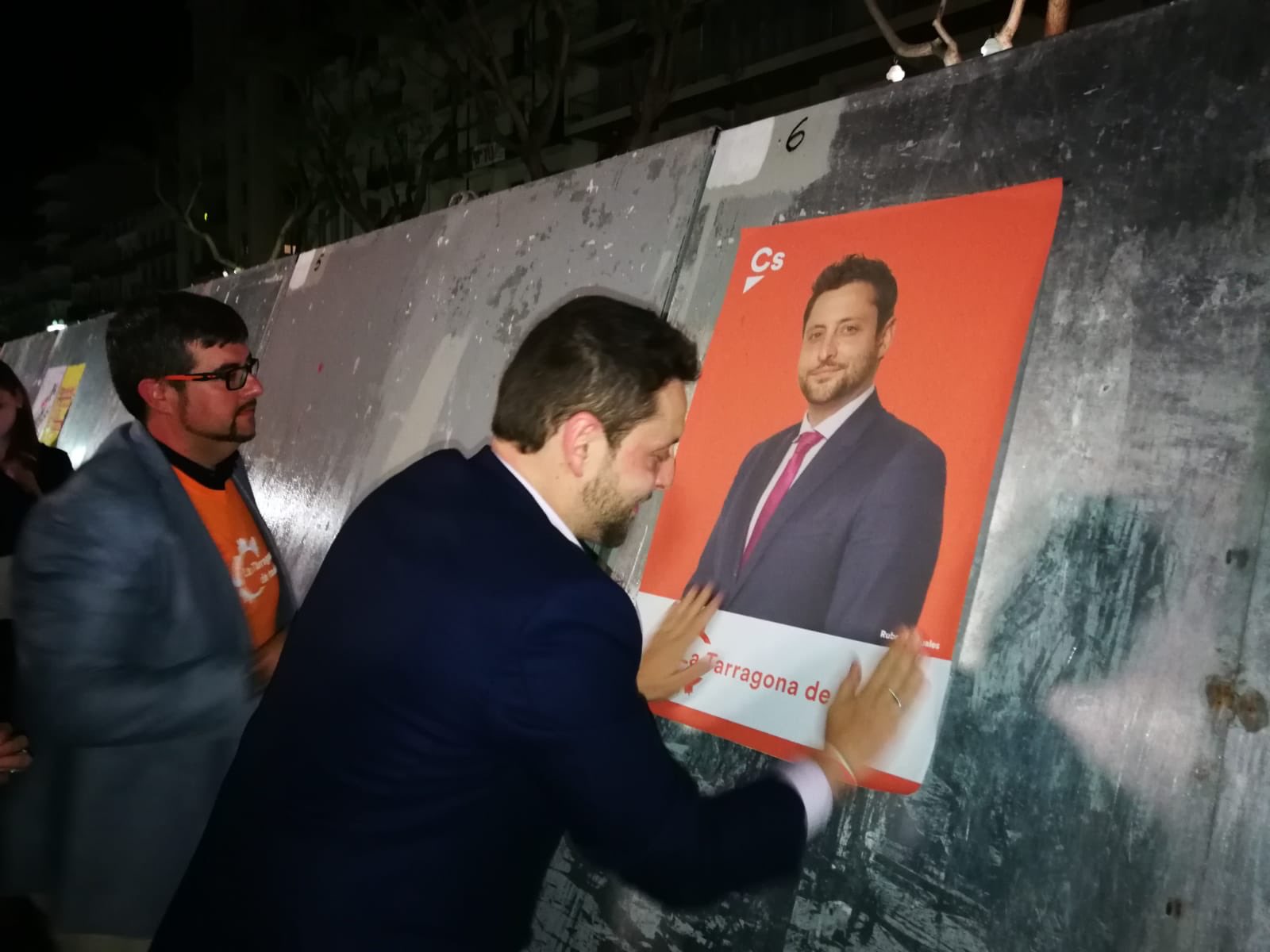 Rubén Viñuales enganxant un cartell electoral de Ciutadans amb la seva imatge en la campanya de 2019