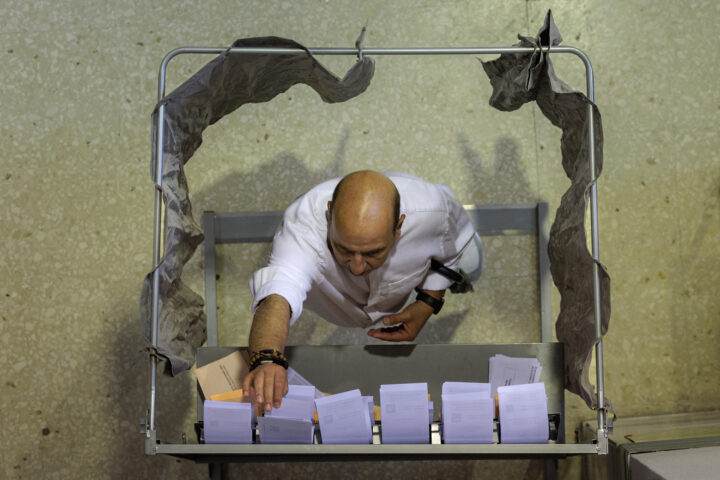 Un elector tria papereta en un col·legi de València. (Fotografia de Biel Aliño)