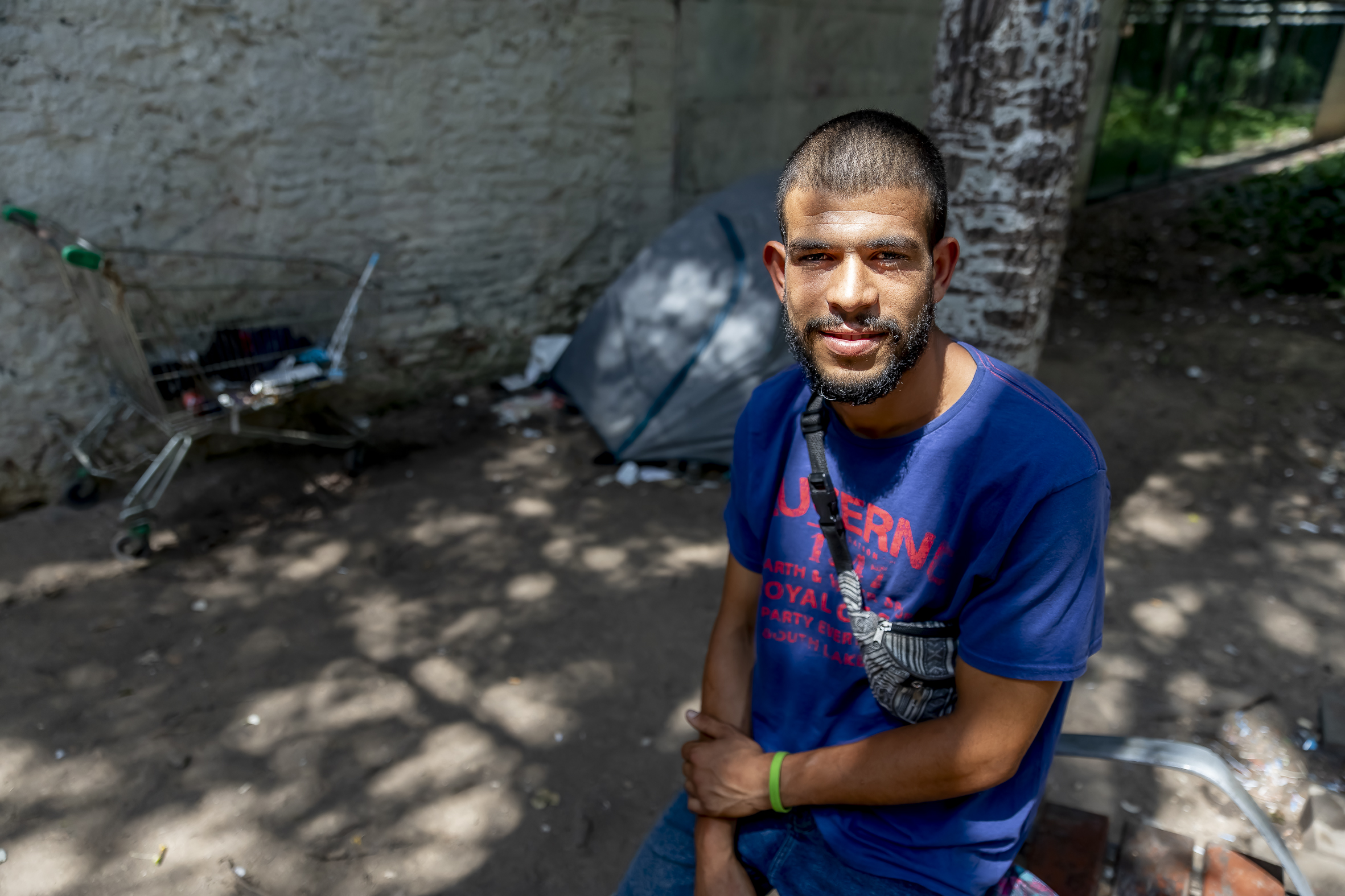 En Hassan, davant una tenda i un carro metàlic, als jardins de Miquel Martí i Pol de Barcelona. (fotografia: Albert Salamé)