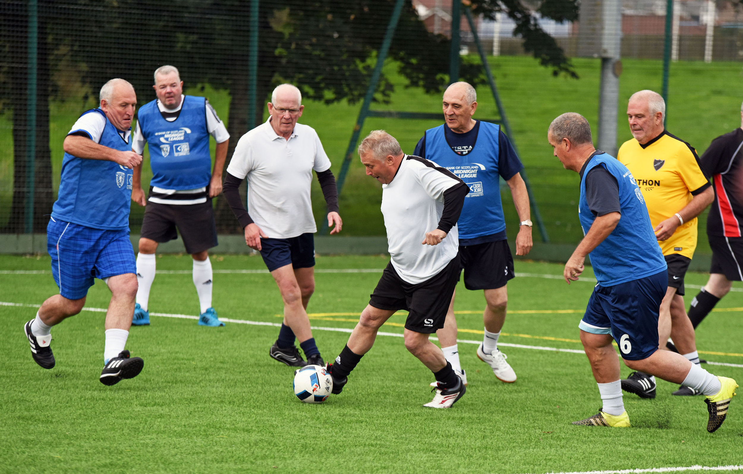 Un grup de jugadors es disputa la pilota en un partit de futbol a peu (fotografia: Walking Football Scotland).