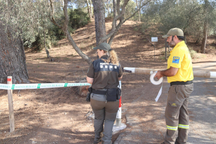Una agent rural i un membre de l'ADF precinten l'accés del Parc Natural del Montgrí (fotografia: ACN / Aleix Freixas).