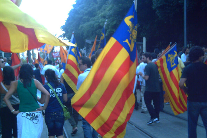 Manifestants portant la nova bandera independentista siciliana, amb les quatre barres i la trisquela.