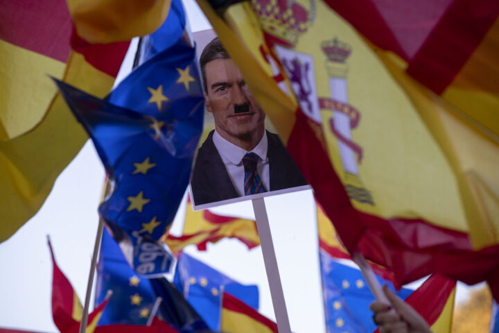 Cartell amb una fotografia de Sánchez amb un bigoti, inspirat en el d'Adolf Hitler, en una protesta contra l'amnistia a Màlaga (fotografia: EFE/Jorge Zapata).