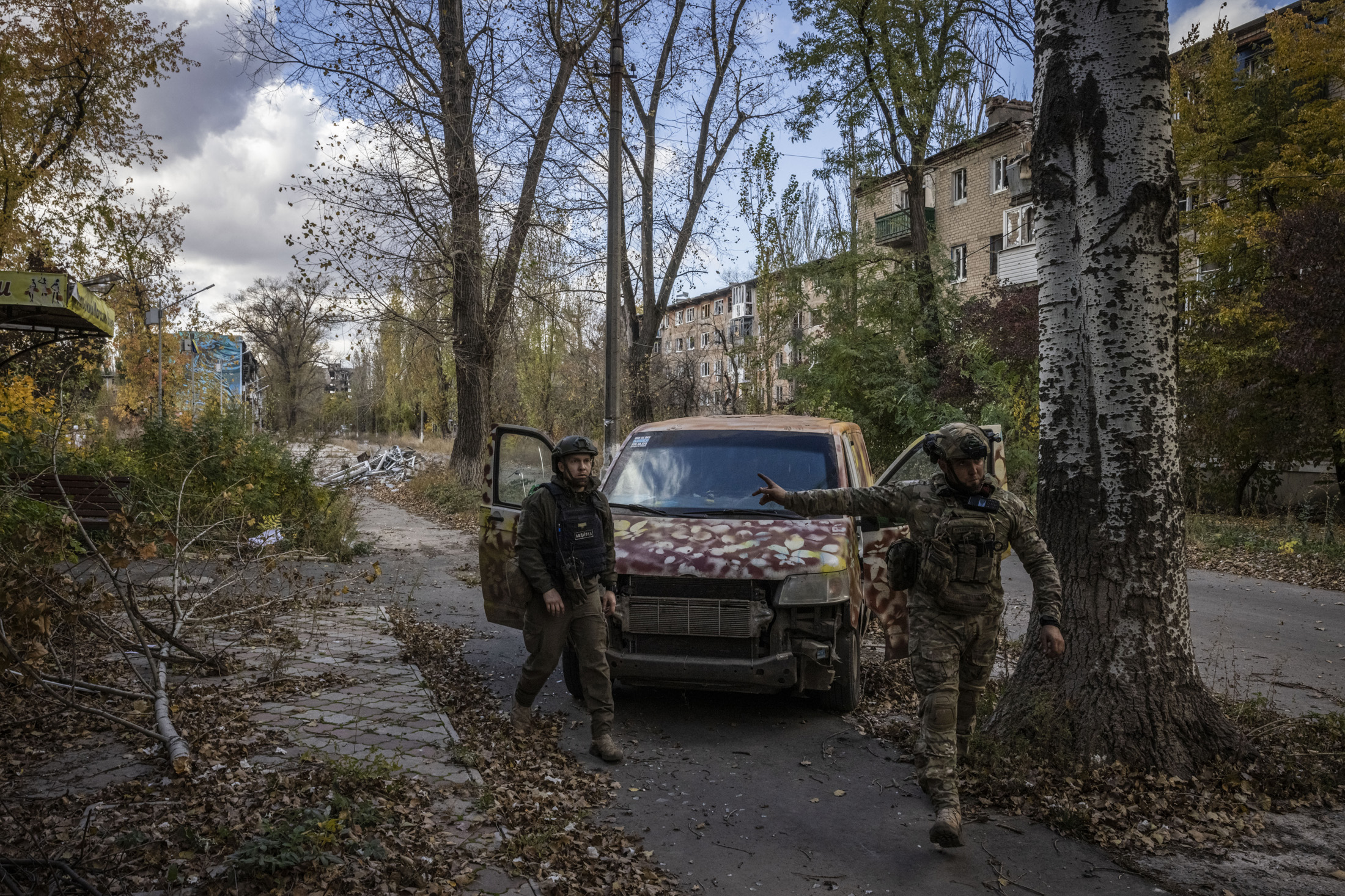 Funcionaris de l'administració militar d'Avdiivka, Ucraïna, donen indicacions en un carrer damnificat el 24 d'octubre de 2023. (Fotografia: Ed Ram per The Washington Post.)