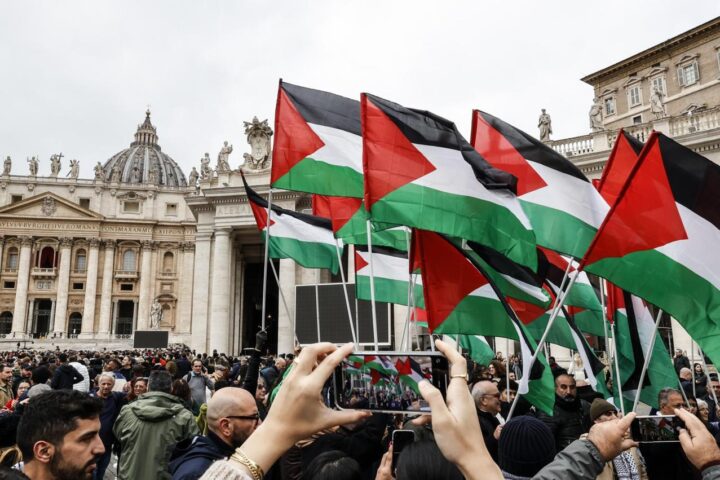 Un grup de persones enarbora banderes palestines davant el Papa, durant la celebració de Nadal. (Fotografia de Fabio Frustadi)