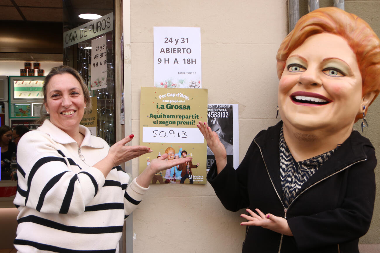 La Grossa de Cap d'Any i la propietària de l'estanc de Barcelona que ha venut el segon premi, el 50913, mostren el número (fotografia: ACN)