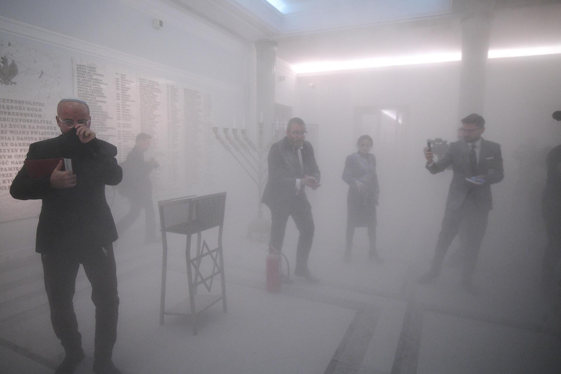 Grzegorz Braun apagant les esmpelmes (fotografia: EFE/EPA/ Marcin Obara).