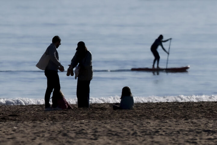 Persones gaudint del bon oratge a la platja de la Malva-rosa de València