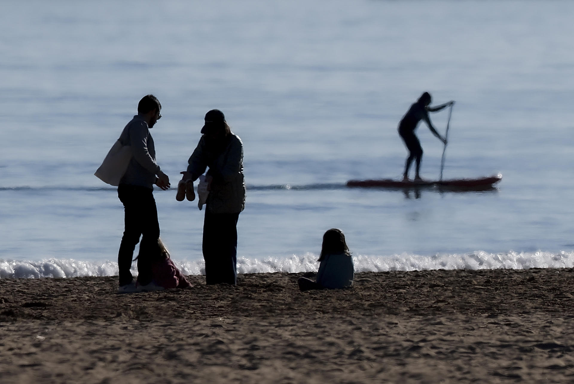 Persones gaudint del bon oratge a la platja de la Malva-rosa de València