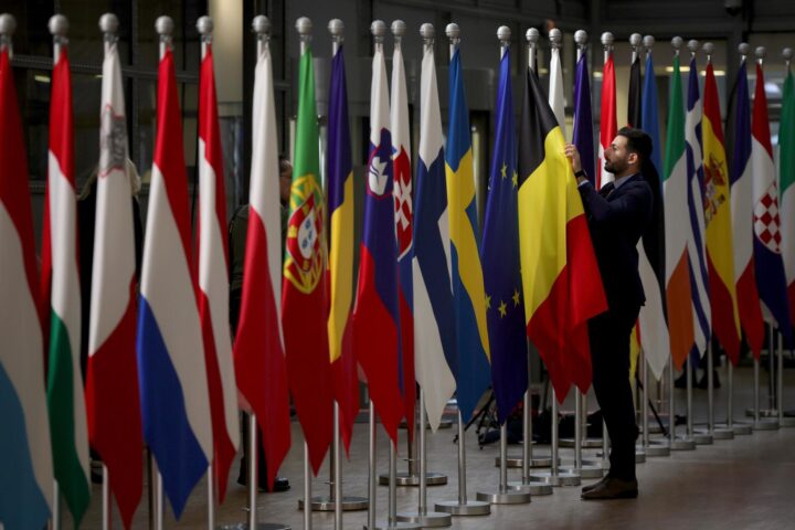 Un funcionari posa bé les banderes dels estats membres de la UE (fotografia: Olivier Matthys).