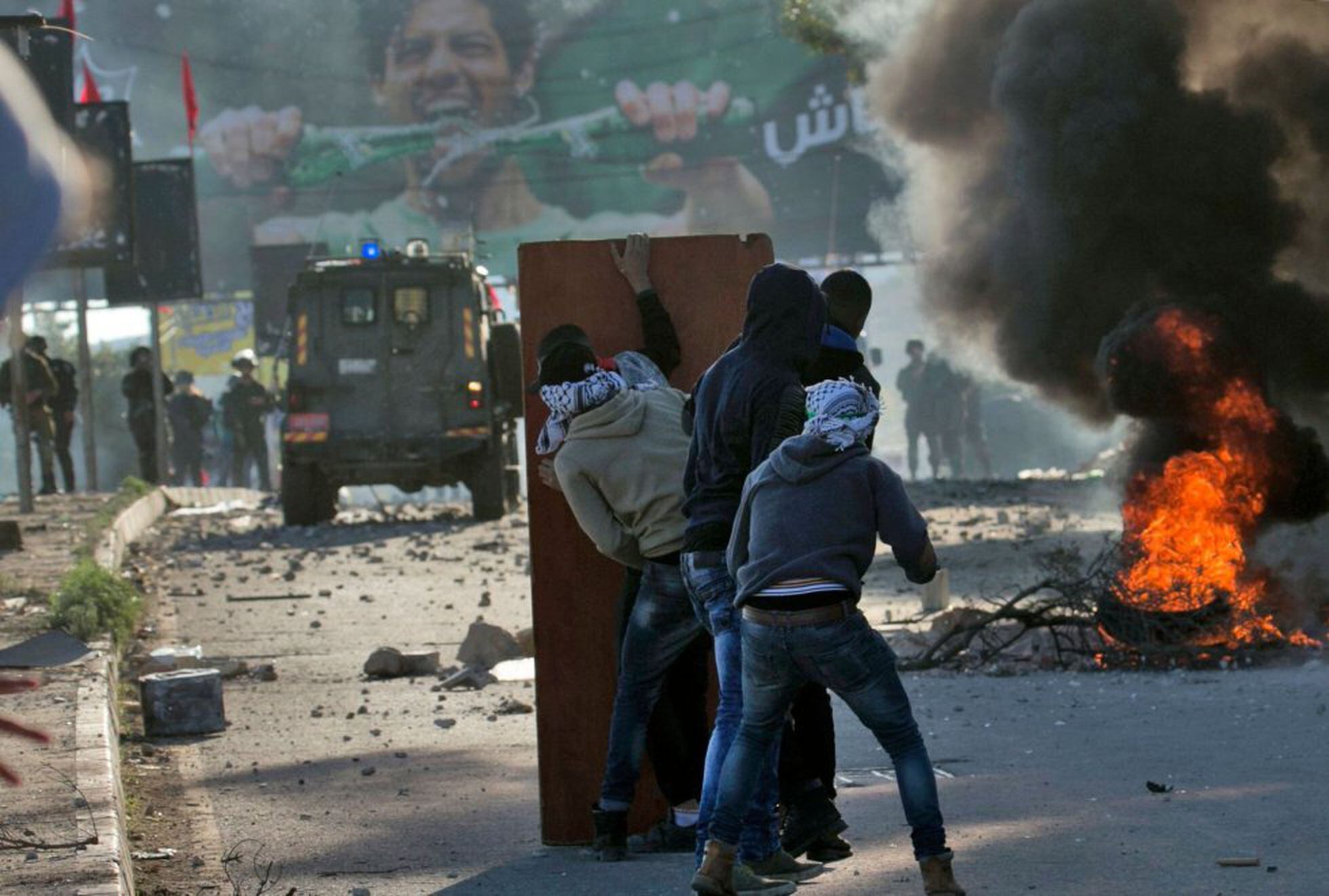 Uns quants palestins es protegeixen de les forces de seguretat israelianes (fotografia: Jaafar Ashtiyeh/AFP).