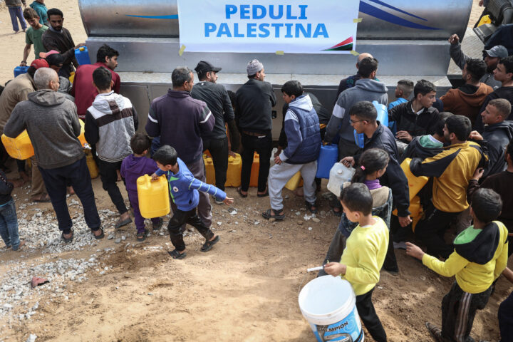 N'Ibrahim, al centre, intenta d'emplenar una ampolla d'aigua a Rafà el diumenge passat (fotografia: Loay Ayyoub/The Washington Post)