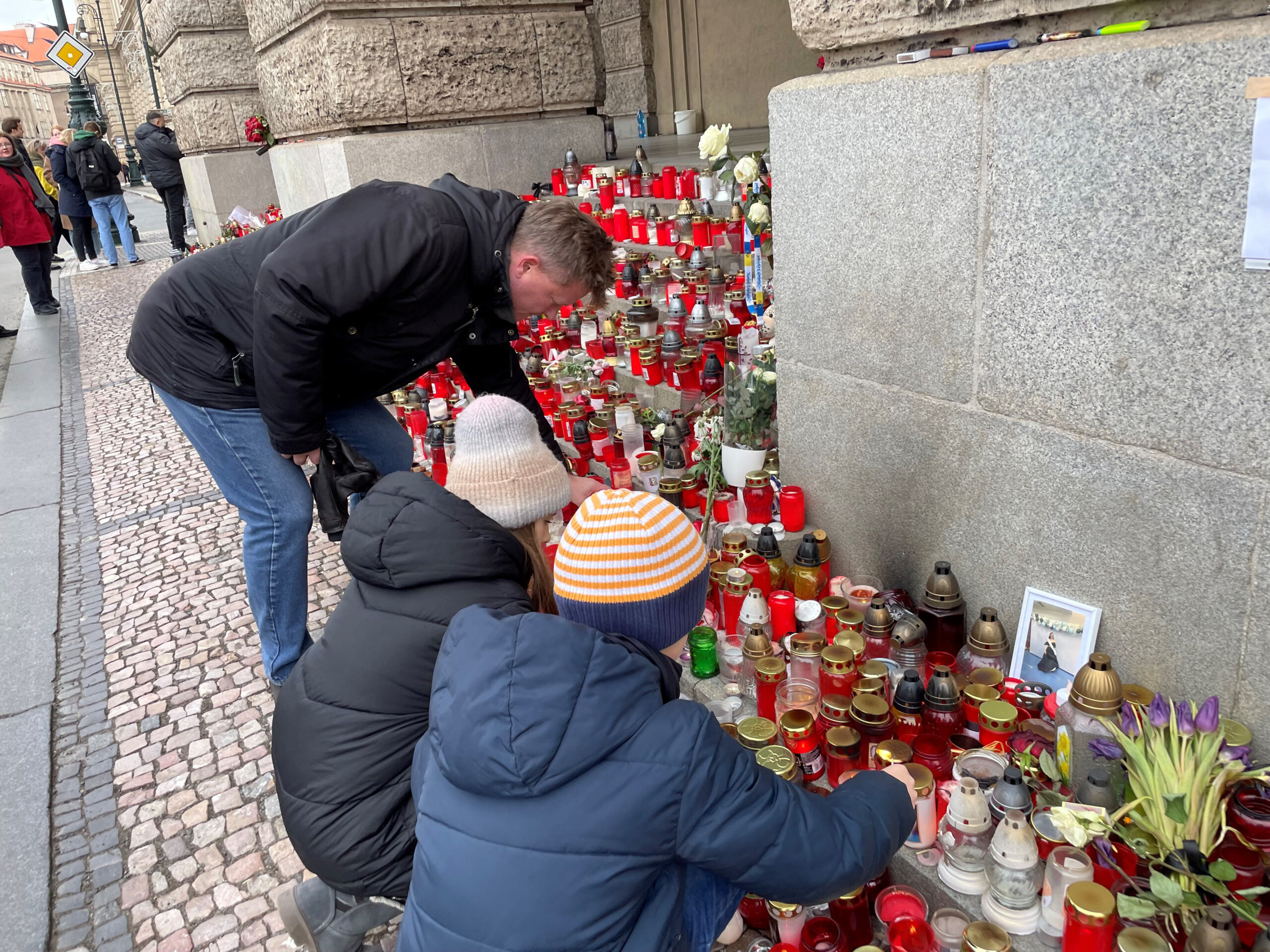 Una família encèn espelmes en record dels morts en la massacre (Fotografia de Petla Dvorak)