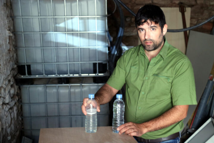 Jordi Arnau amb dues mostres d'aigua: una de reaprofitada i una altra d'embotellada (fotografia: ACN / Nia Escolà).