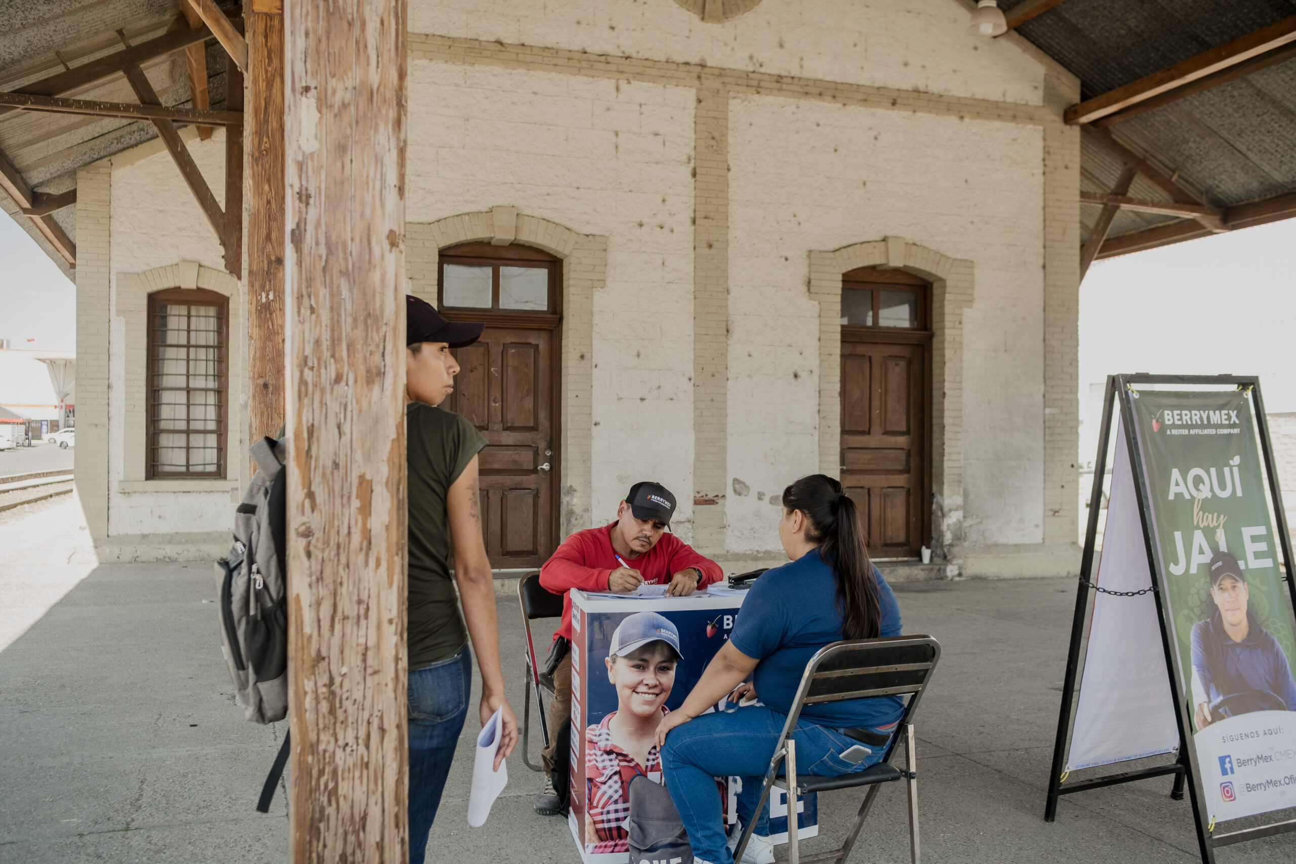 Dues dones signen per una feina agrícola en una de les taules que intenta captar treballadors per al camp (fotografia: Fred Ramos).