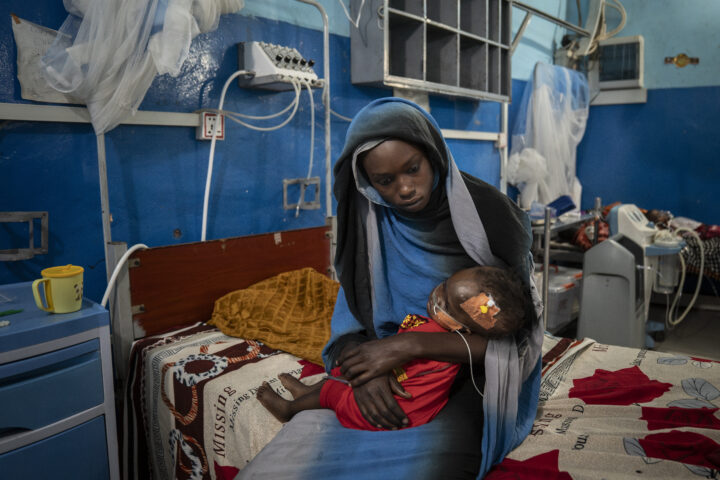 Mawada Mohamed, de 17 anys, sosté la seva germaneta d’1 any, Aza Ismail, que és ingressada a la unitat de malnutrició pediàtrica de Metges Sense Fronteres a l’Hospital d’El Geneina, al Darfur occidental, al Sudan. Quan la lluita va arribar al barri de les germanes a Ardamata, als afores d’El Geneina, la seva mare va ser assassinada i un tros de metralla va travessar el cap d’Aza. Encara és encastat al seu crani i ha causat complicacions greus, com ara sèpsia i meningitis, que també l’han duta a la malnutrició (fotografia: Diana Zeyneb Alhindawi/The Washington Post).